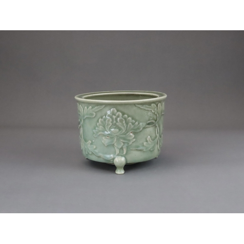 62 - A Longquan Celadon Peony Tripod Censer, early Ming dynasty,   the cylindrical vessel with applied pe... 