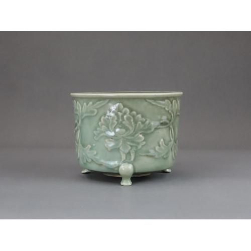 62 - A Longquan Celadon Peony Tripod Censer, early Ming dynasty,   the cylindrical vessel with applied pe... 