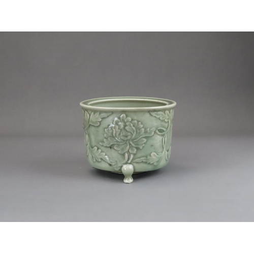 62 - A Longquan Celadon Peony Tripod Censer, early Ming dynasty,   the cylindrical vessel with applied pe... 