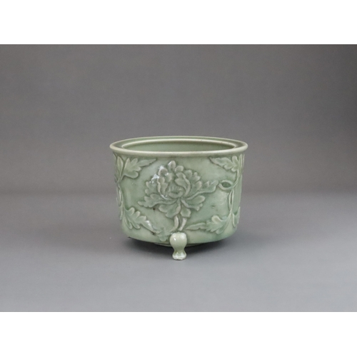 62 - A Longquan Celadon Peony Tripod Censer, early Ming dynasty,   the cylindrical vessel with applied pe... 