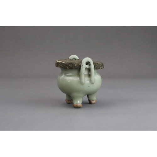 63 - A Longquan Celadon Tripod Incense Burner, Yuan dynasty  the compressed globular body rising from thr... 