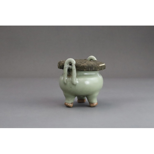 63 - A Longquan Celadon Tripod Incense Burner, Yuan dynasty  the compressed globular body rising from thr... 