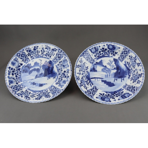 83 - A Pair of Blue and White Dishes with Landscapes, Kangxi, each with a central medallion of a rustic h... 