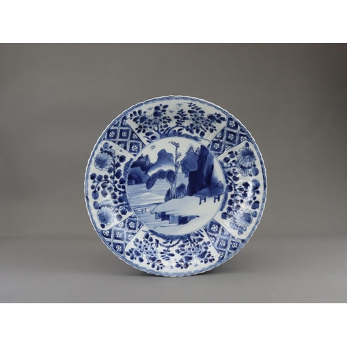 83 - A Pair of Blue and White Dishes with Landscapes, Kangxi, each with a central medallion of a rustic h... 