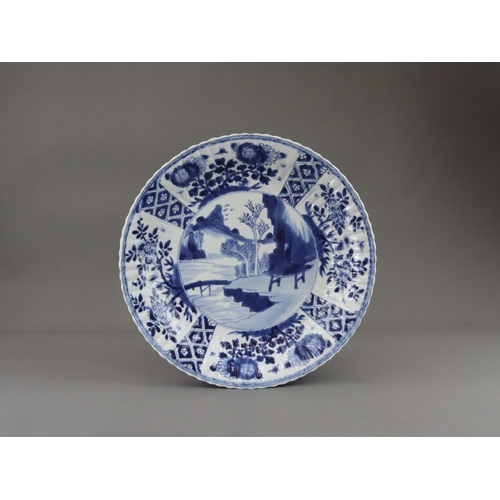 83 - A Pair of Blue and White Dishes with Landscapes, Kangxi, each with a central medallion of a rustic h... 