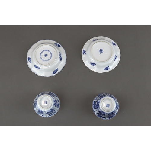 85 - Blue and White: Two Cups and Two Saucers, Kangxi the barbed moulded cups with panelled bird and flow... 