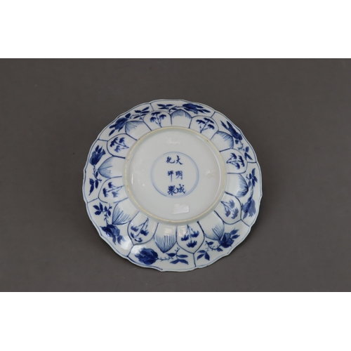 89 - A Blue and White Figural Dish, Kangxi moulded in floral shape, painted in blue and white with a lady... 