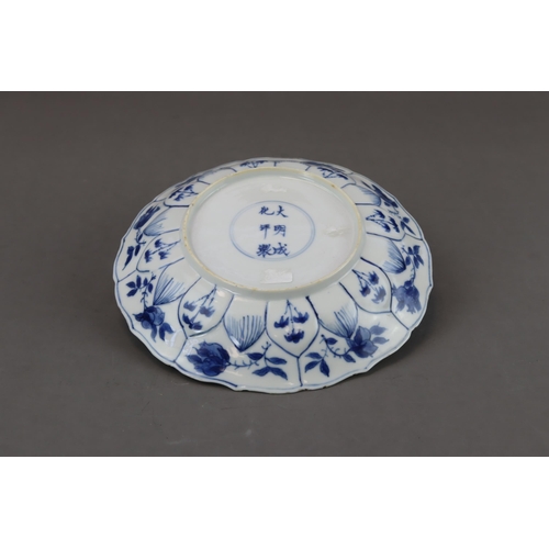 89 - A Blue and White Figural Dish, Kangxi moulded in floral shape, painted in blue and white with a lady... 