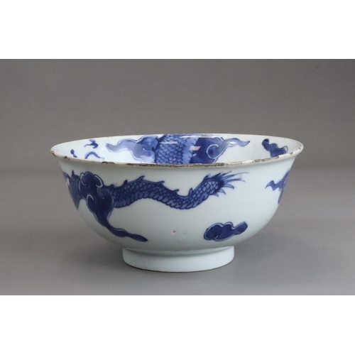 95 - A Blue and White Dragon Bowl, early 18th century, painted in strong blue with a vigorous four clawed... 