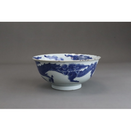 95 - A Blue and White Dragon Bowl, early 18th century, painted in strong blue with a vigorous four clawed... 