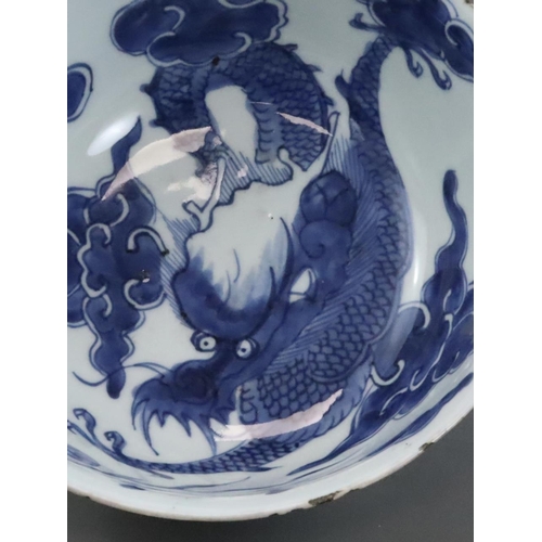 95 - A Blue and White Dragon Bowl, early 18th century, painted in strong blue with a vigorous four clawed... 