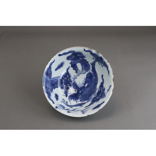 95 - A Blue and White Dragon Bowl, early 18th century, painted in strong blue with a vigorous four clawed... 