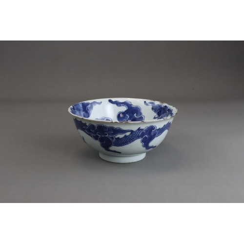 95 - A Blue and White Dragon Bowl, early 18th century, painted in strong blue with a vigorous four clawed... 