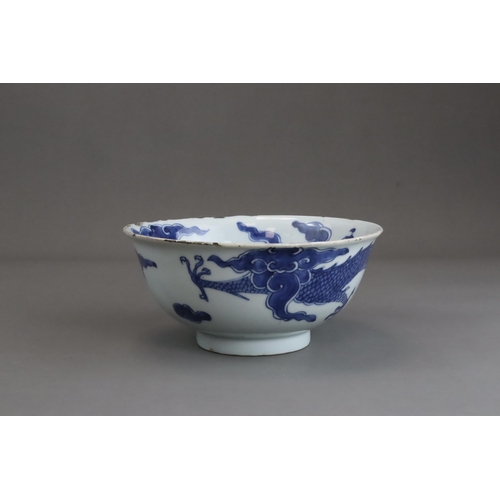 95 - A Blue and White Dragon Bowl, early 18th century, painted in strong blue with a vigorous four clawed... 