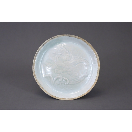 38 - A Qingbai moulded 'Dragon' Dish, Song/Yuan dynasty thinly potted, the slightly convex interior mould... 