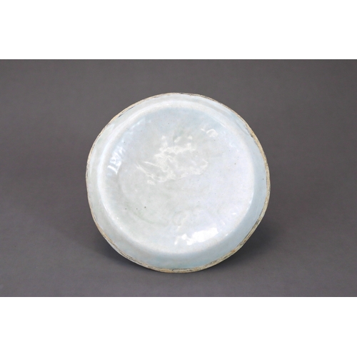 38 - A Qingbai moulded 'Dragon' Dish, Song/Yuan dynasty thinly potted, the slightly convex interior mould... 