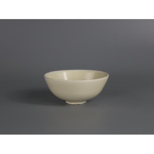 56 - A Ding white-glazed Bowl, Song dynasty with the deep rounded sides rising from a short foot, covered... 