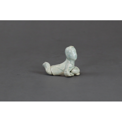 6 - A Qingbai Figure of a Boy, Song dynasty depicted with a lock of hair on his forehead, lying on his f... 