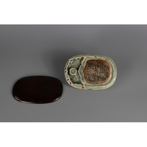 1 - A Longquan Celadon Inkstone, Ming dynasty of double-sided oval form with a shallow indented ovoid we... 