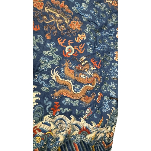 135 - An Embroidered Blue Ground Dragon Robe, 19th century with golden dragons among clouds, interspersed ... 