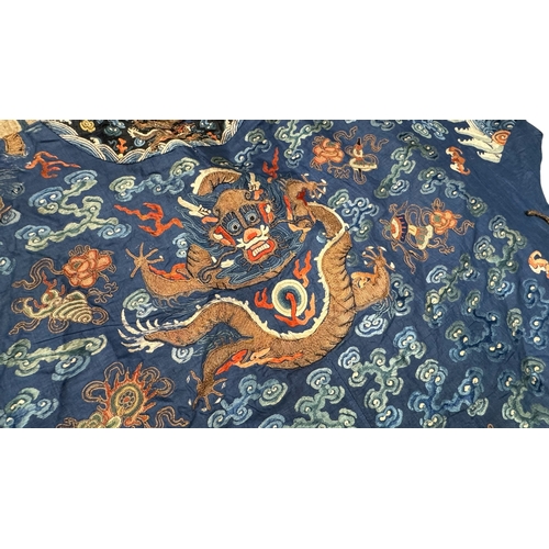 135 - An Embroidered Blue Ground Dragon Robe, 19th century with golden dragons among clouds, interspersed ... 