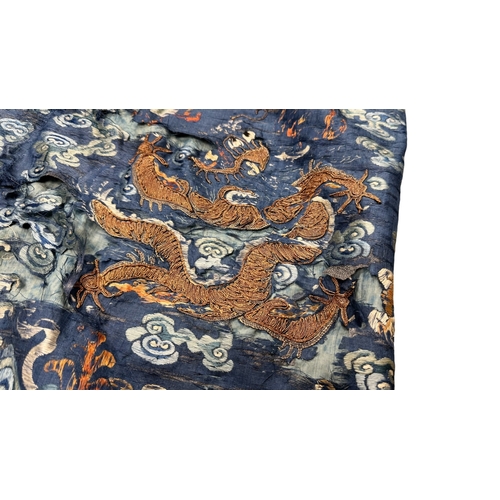 135 - An Embroidered Blue Ground Dragon Robe, 19th century with golden dragons among clouds, interspersed ... 