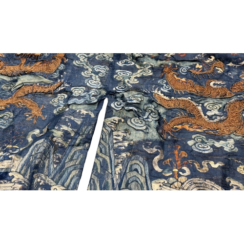 135 - An Embroidered Blue Ground Dragon Robe, 19th century with golden dragons among clouds, interspersed ... 