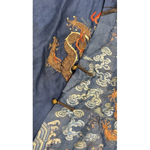 135 - An Embroidered Blue Ground Dragon Robe, 19th century with golden dragons among clouds, interspersed ... 