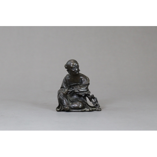 166 - A Bronze Seated Sage, 17th century,  with long beard and serene gaze,  finely cast leaning on a rock... 