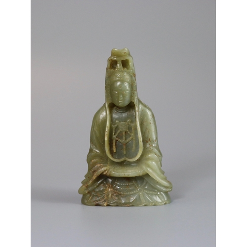 191 - A Jade Guanyin, 17th century,  carved from an olive green stone, the serene deity seated upright, we... 