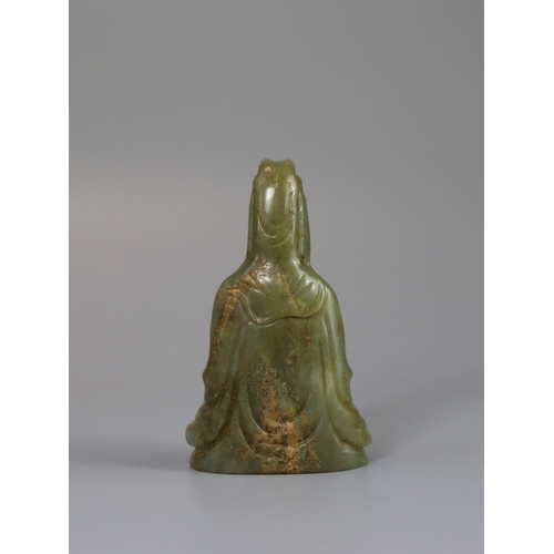 191 - A Jade Guanyin, 17th century,  carved from an olive green stone, the serene deity seated upright, we... 