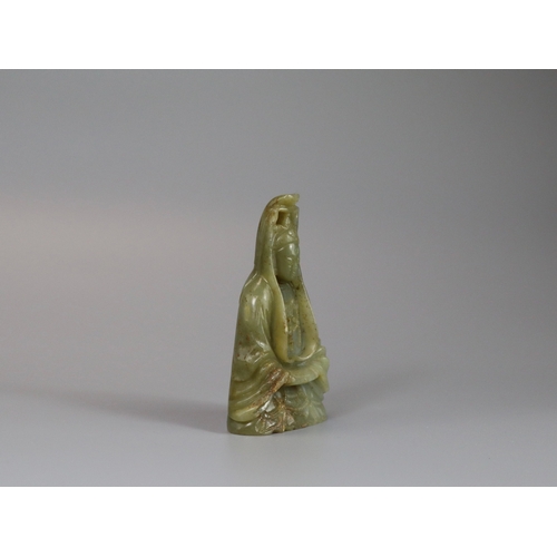 191 - A Jade Guanyin, 17th century,  carved from an olive green stone, the serene deity seated upright, we... 