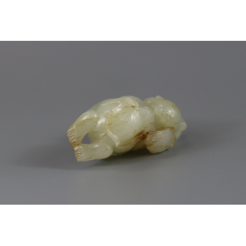 193 - A Pale Celadon Jade Boy, 18th century,  finely carved with the smiling reclining boy holding a leafy... 