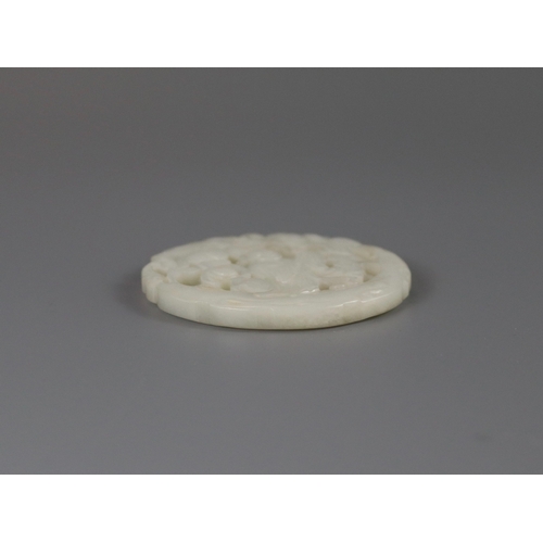 201 - A Pierced White Jade Roundel, 18th century,  carved with a gentleman standing on a curved flowering ... 