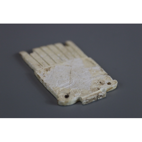 206 - A Carved Jade 'Mask' Comb, Shang dynasty carved with a rectangular handle with two piercings, that i... 