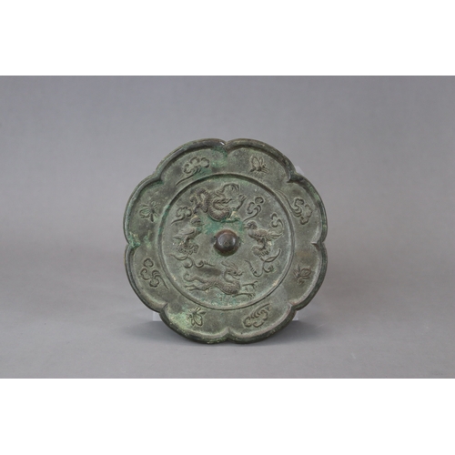 212 - A Bronze Mirror, Tang dynasty,  with petal lobed rim, the central medallion crisply moulded around t... 