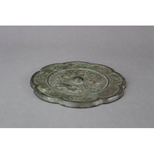 212 - A Bronze Mirror, Tang dynasty,  with petal lobed rim, the central medallion crisply moulded around t... 