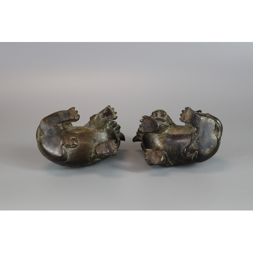 461 - A Pair of Bronze Buddhist Lions, Qing dynasty, the seated beasts with heads turned in ferocious snar... 