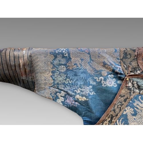 138 - A Blue Silk Gauze Dragon Robe, 19th century finely worked in gold brocade and colours on a deep blue... 