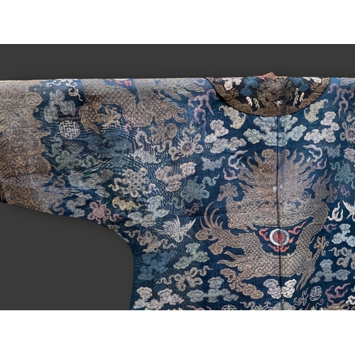 138 - A Blue Silk Gauze Dragon Robe, 19th century finely worked in gold brocade and colours on a deep blue... 