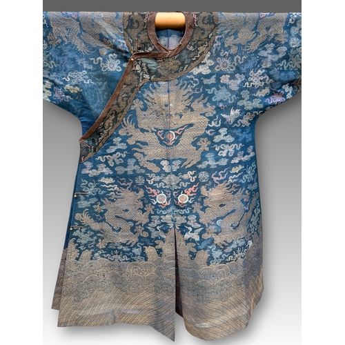 138 - A Blue Silk Gauze Dragon Robe, 19th century finely worked in gold brocade and colours on a deep blue... 