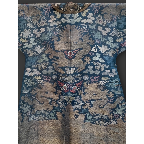 138 - A Blue Silk Gauze Dragon Robe, 19th century finely worked in gold brocade and colours on a deep blue... 