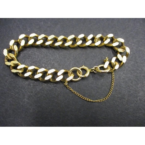 98 - A heavy 9ct gold embossed curb link bracelet. With working clasp and safety chain. Approximate weigh... 