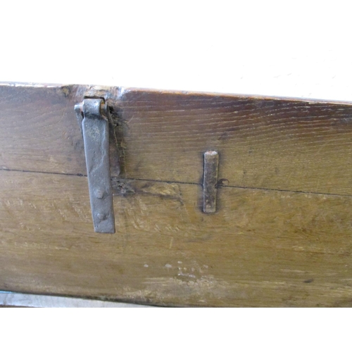 385 - An antique elm coffer having original lock and hinges, carving to front panel.