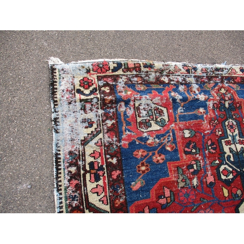 343 - A vintage Persian hand knotted wool rug, in well used condition