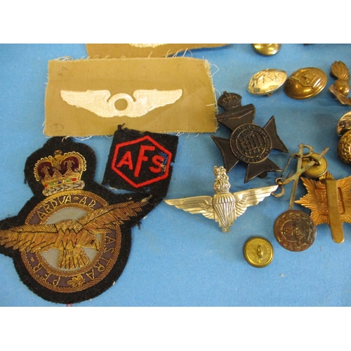 211 - A parcel of military cloth and metal badges and buttons
