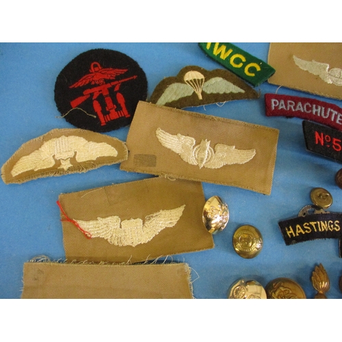 211 - A parcel of military cloth and metal badges and buttons