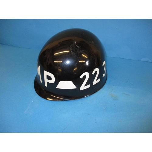 213 - Two vintage army helmets, a Military police helmet and a Metropolitan police helmet