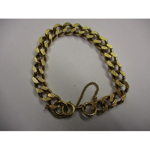 98 - A heavy 9ct gold embossed curb link bracelet. With working clasp and safety chain. Approximate weigh... 