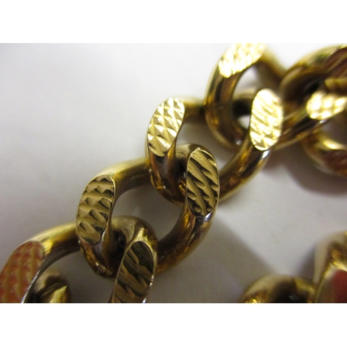 98 - A heavy 9ct gold embossed curb link bracelet. With working clasp and safety chain. Approximate weigh... 